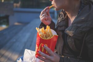 Kvinde spiser pomfritter udenfor
