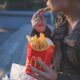 Kvinde spiser pomfritter udenfor
