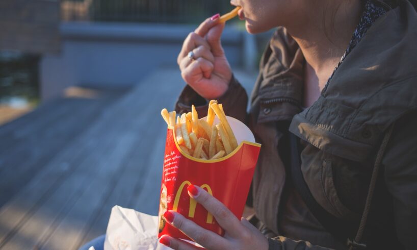 Kvinde spiser pomfritter udenfor